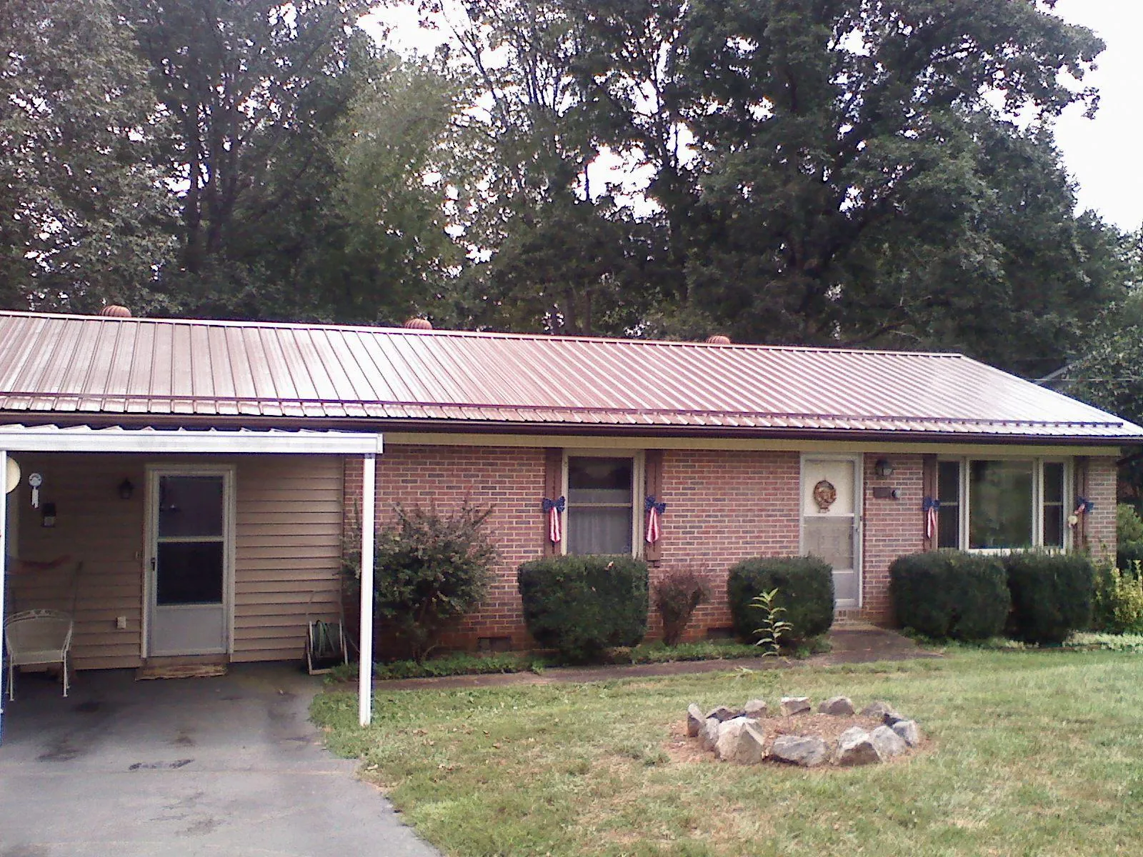Bronze metal roof and carport on a brick ranch home — Roof Repair work by our crew in Zionsville